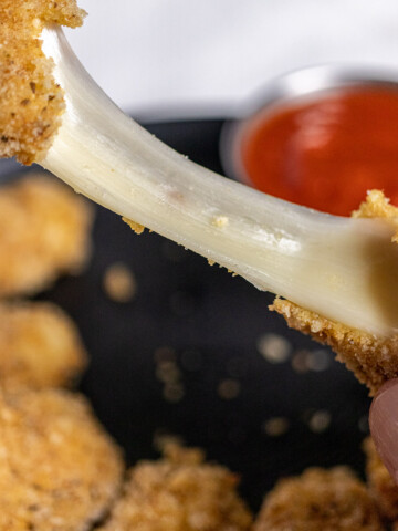 close up of a cheese pull from a baked mozzarella stick
