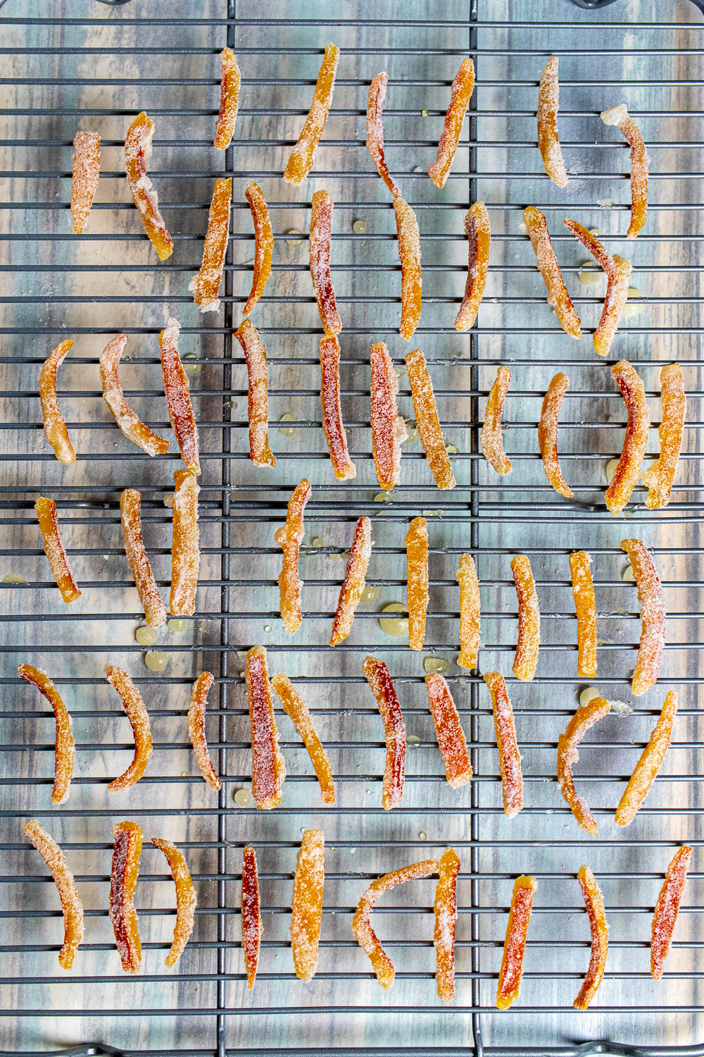overhead view of candied orange peels drying on a cooling rack