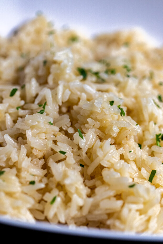 close up of garlic fried rice garnished with parsely 