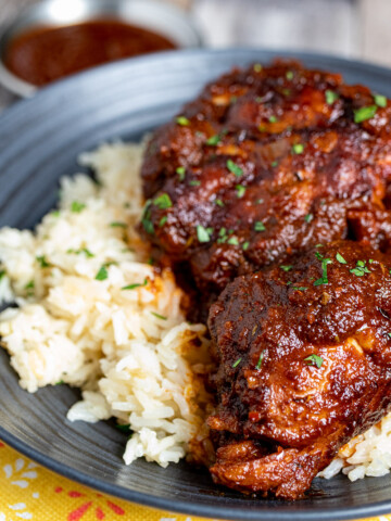 Mexican adobo chicken with rice on a black plate