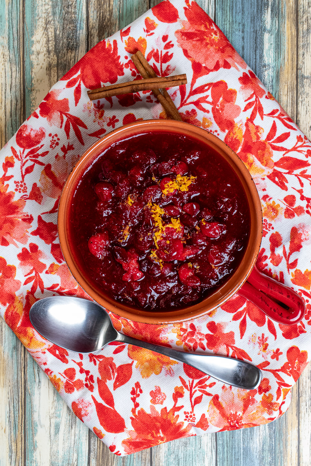 overhead view of cranberry sauce with orange zest on top in an orange bowl