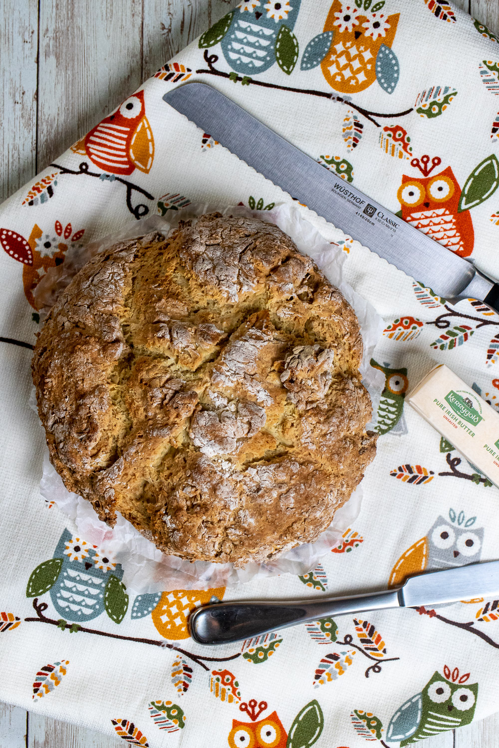 overhead view of traditional Irish soda bread with a bread knife and Irish butter