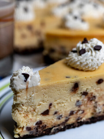 close up view of a slice of Bailey's cheesecake with chocolate chips