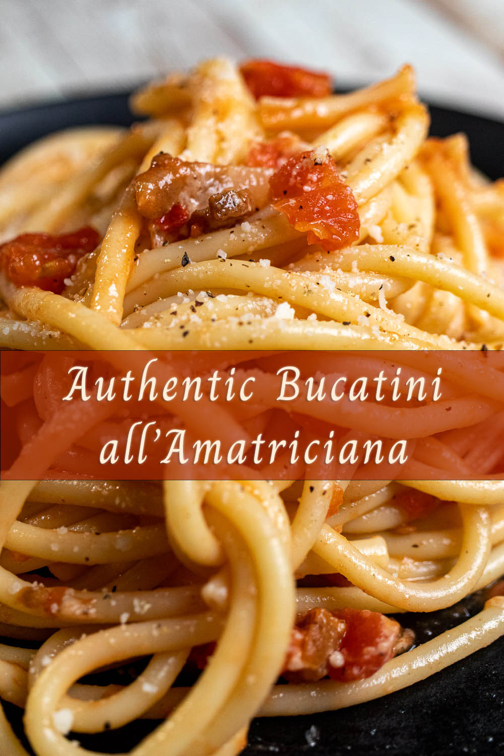 Authentic bucatini all' amatriciana served on a black plate.