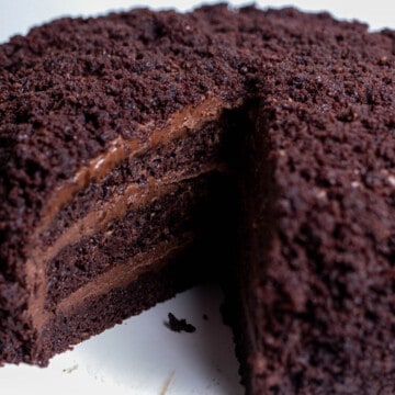 Brooklyn blackout chocolate cake with a slice removed, revealing 3 layers of chocolate cake with a pudding frosting.