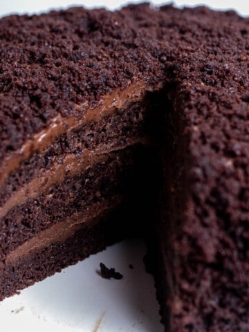 Brooklyn blackout chocolate cake with a slice removed, revealing 3 layers of chocolate cake with a pudding frosting.