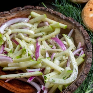 Close up view of fennel apple slaw in a wooden bowl.