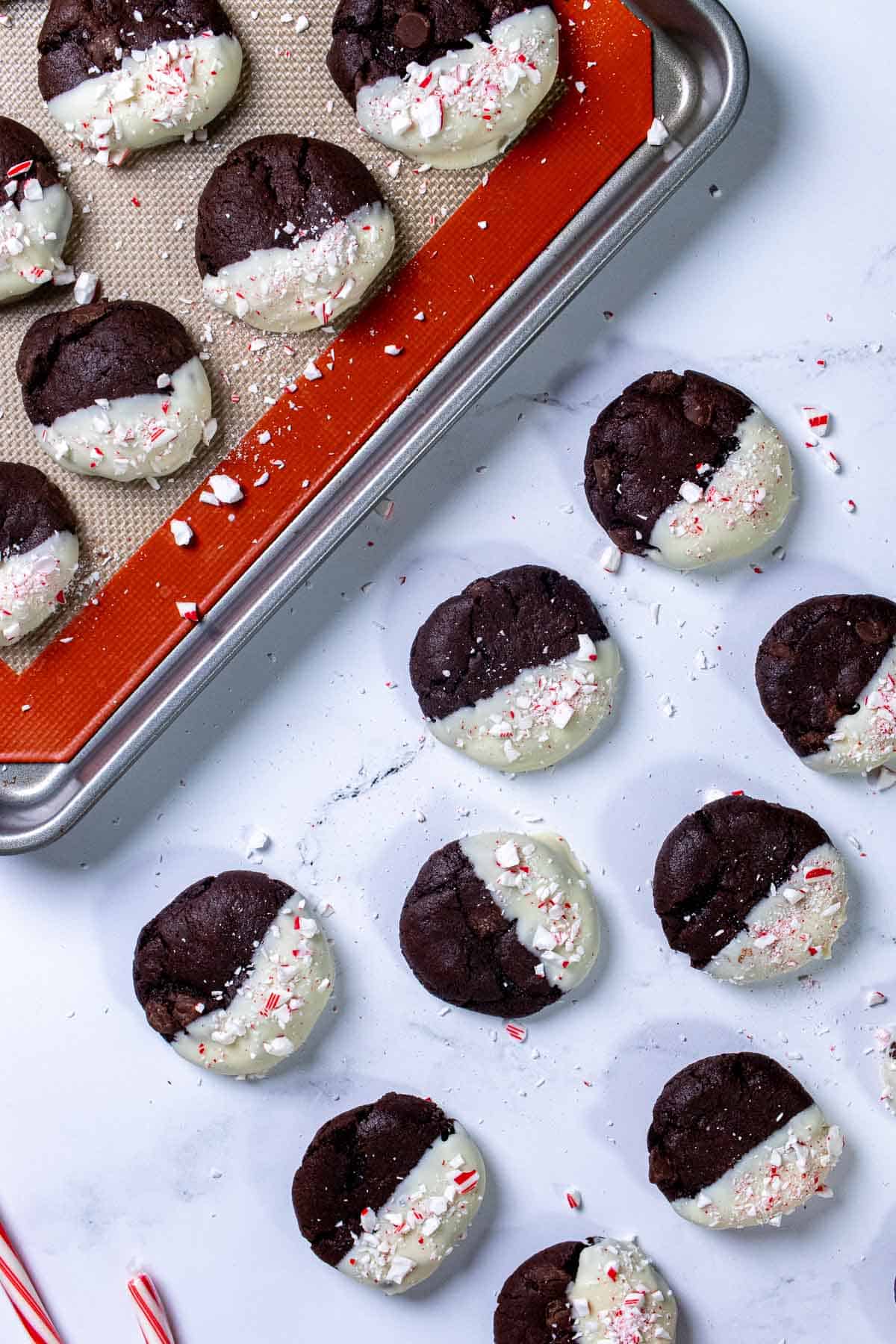 Overhead view of peppermint mocha cookies on a sheet pan and some on marble.