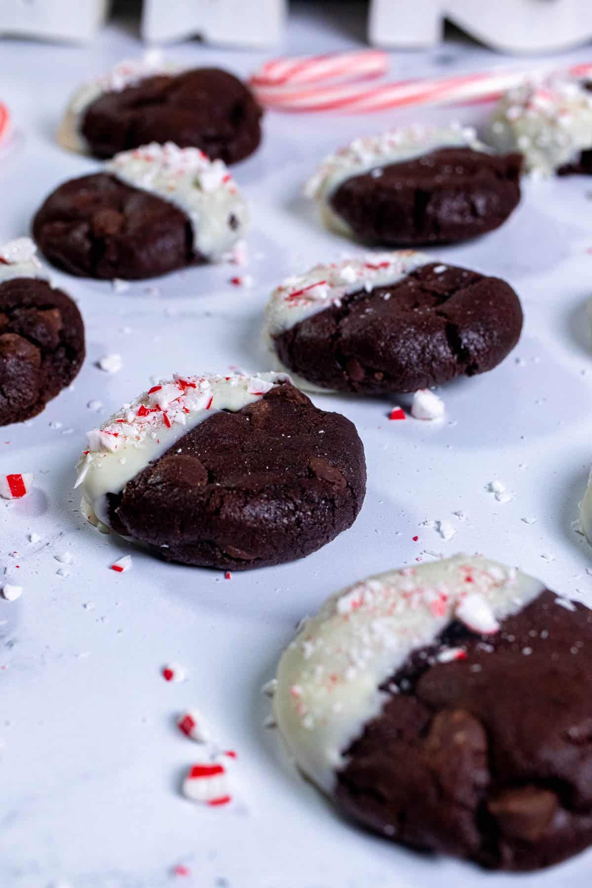 Angled view of peppermint mocha cookies on marble with bits of candy canes around them.