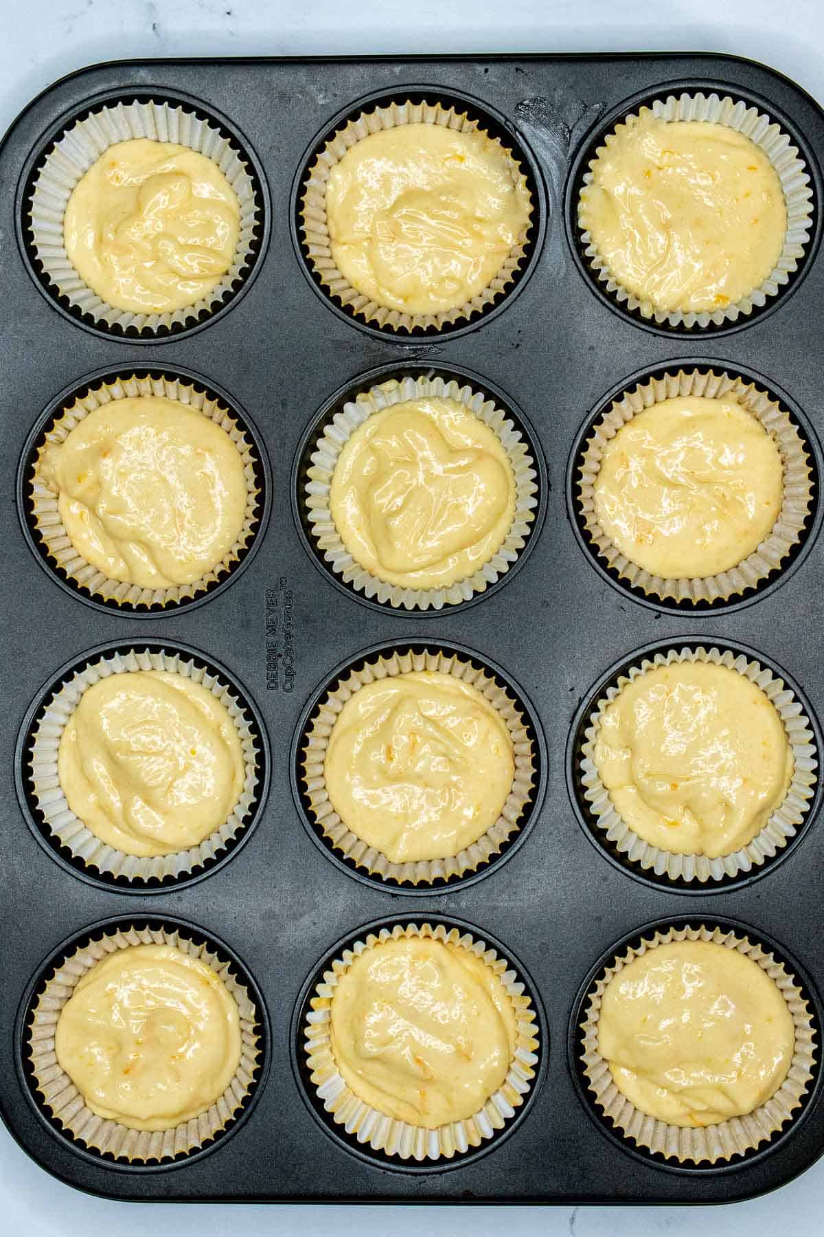 Meyer lemon cupcake batter added to lined muffin tin.