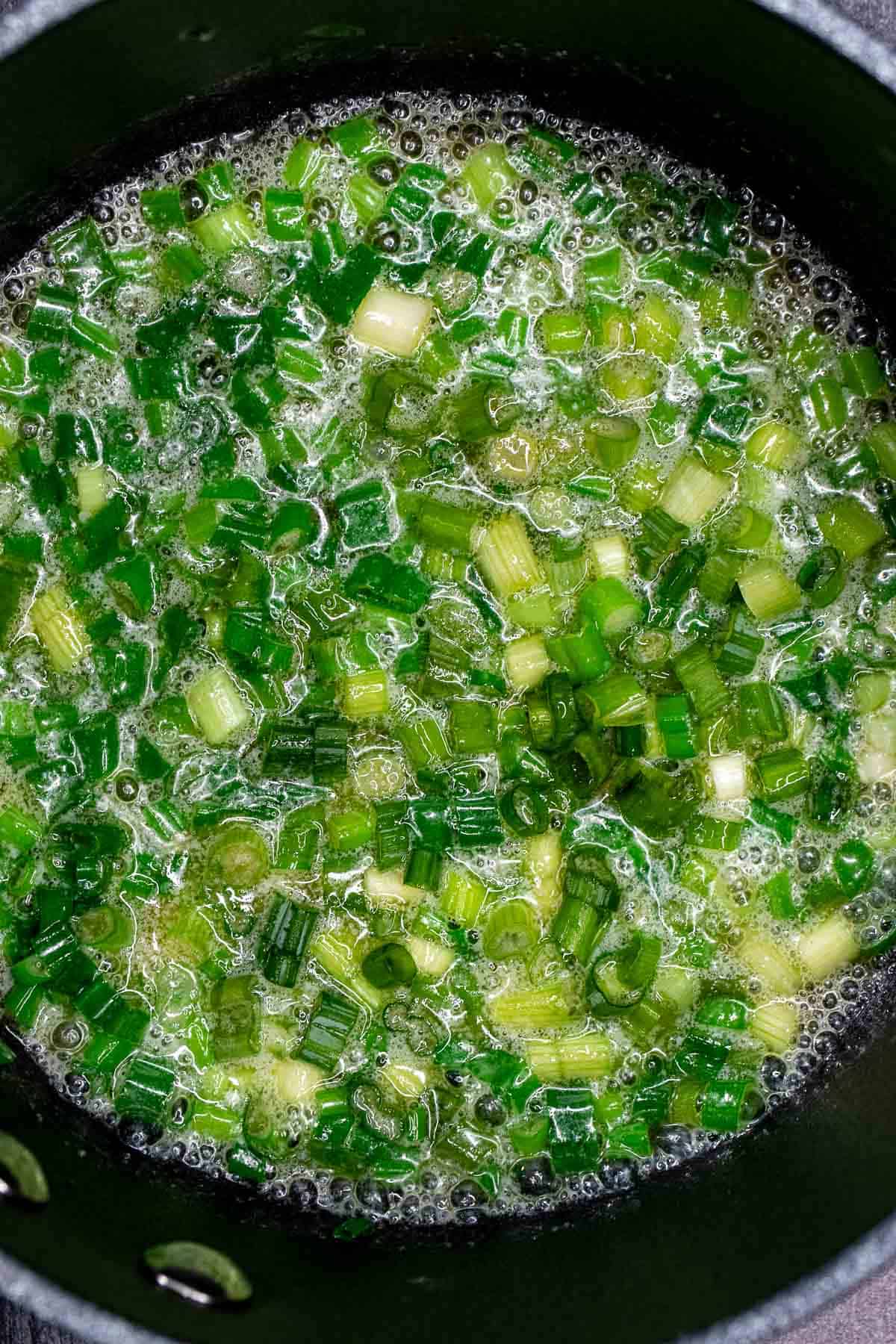 Melted butter and scallions in a saucepan.