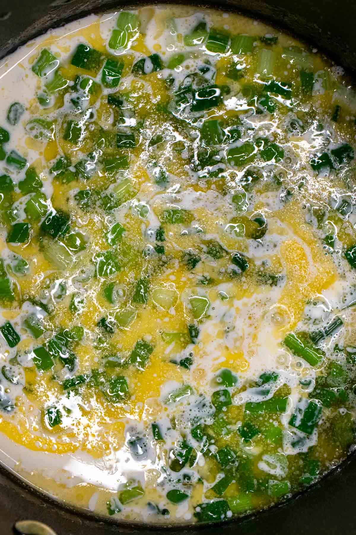 Whole milk added to melted butter and scallions to infuse the milk with their flavor.