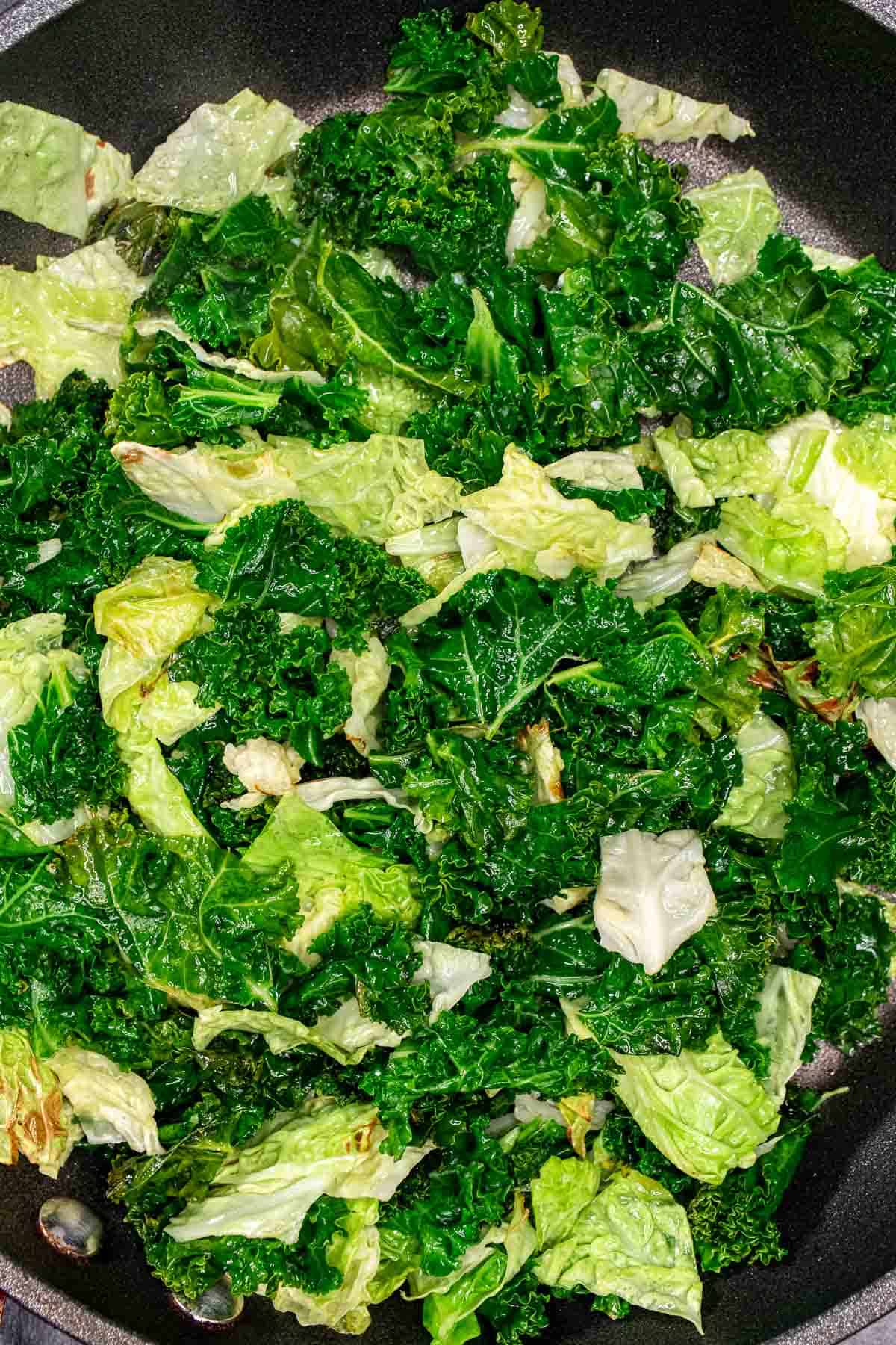 Cabbage and kale sautéed down in Irish butter in a skillet.