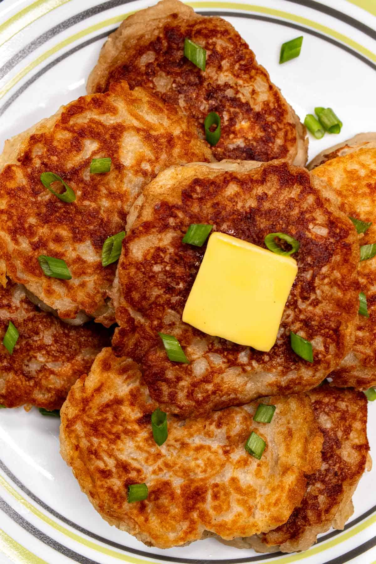 Overhead view of Irish boxty on a plate topped with Irish butter and scallions.