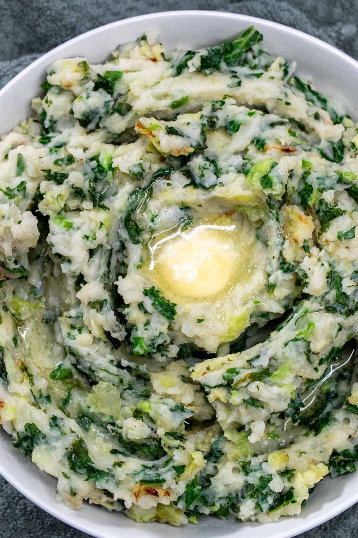 Overhead view of Irish colcannon in a bowl with a pool of butter in the center.