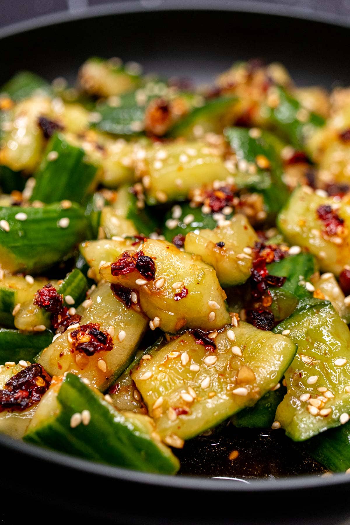 Close view of Chinese smashed cucumber salad with sesame seeds and chili crisp.