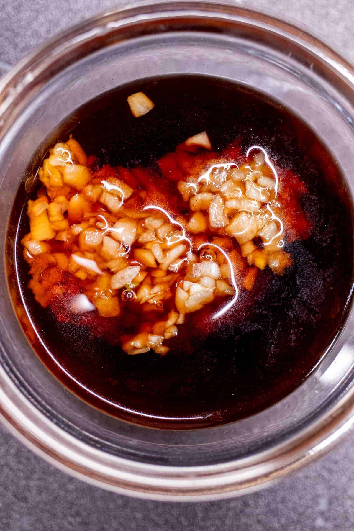 Minced garlic resting in small bowl of Chinese black vinegar.