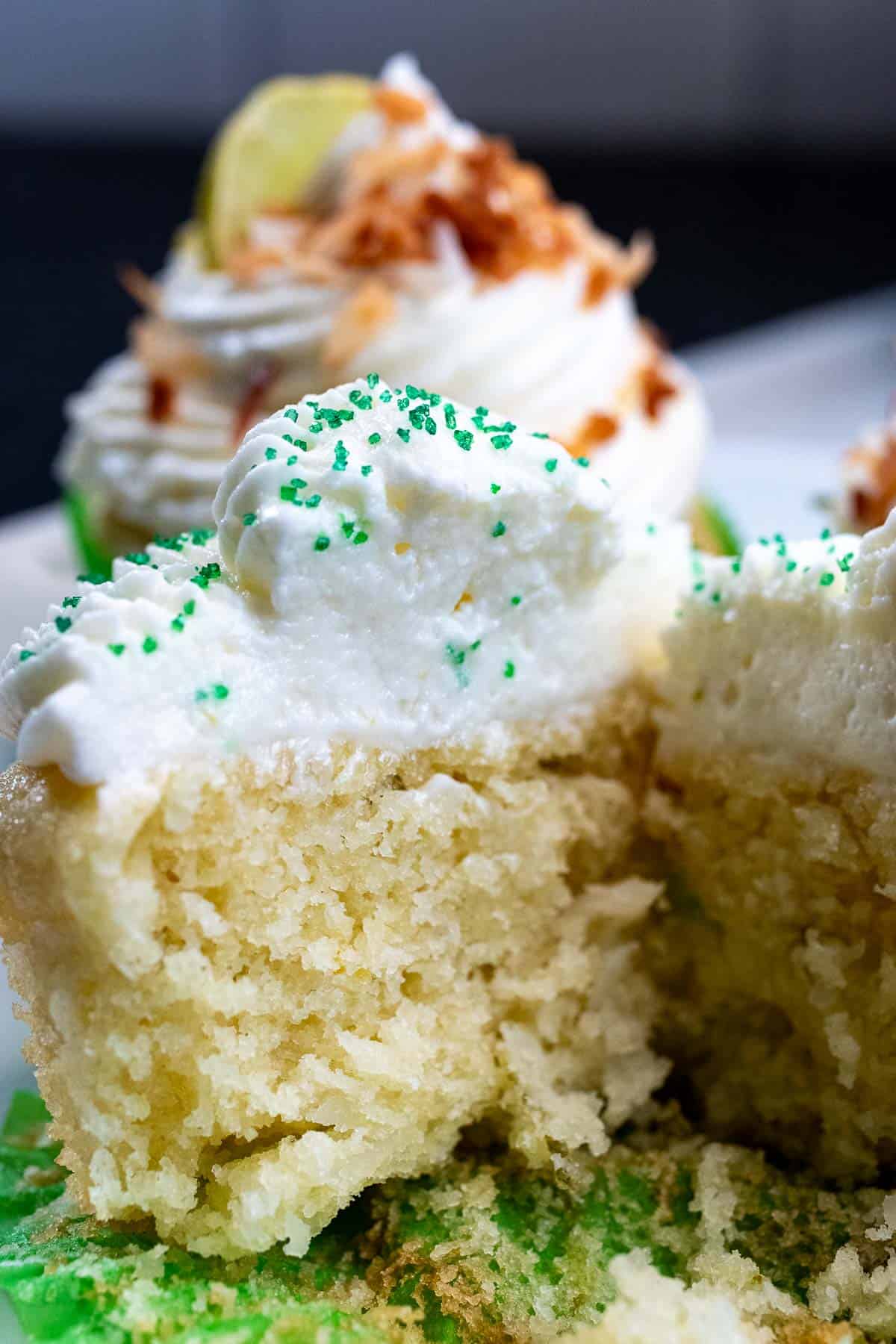 A key lime coconut cupcake cut in half to see the inside.