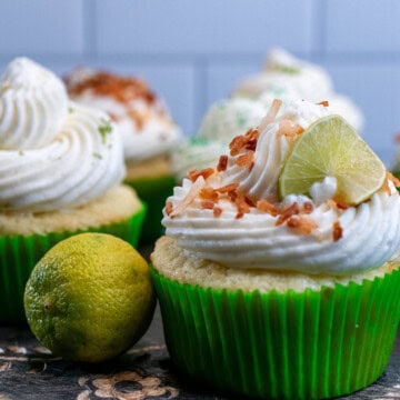 Key lime coconut cupcakes topped with cream cheese frosting and various decorations.