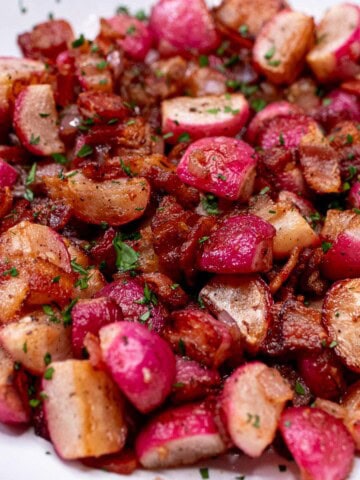 Sauteed radishes with bacon and shallots in a bowl.