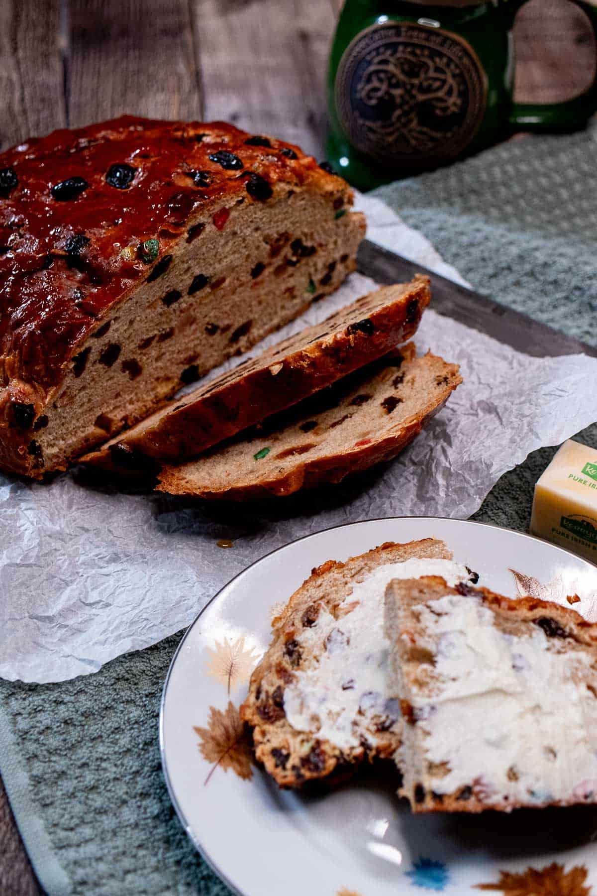 A sliced loaf of Irish barmbrack with some toasted and buttered slices on a plate.