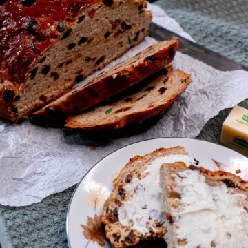 A sliced loaf of Irish barmbrack with some toasted and buttered slices on a plate.