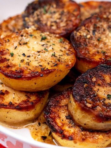 A serving bowl full of crispy, roasted melting potatoes.