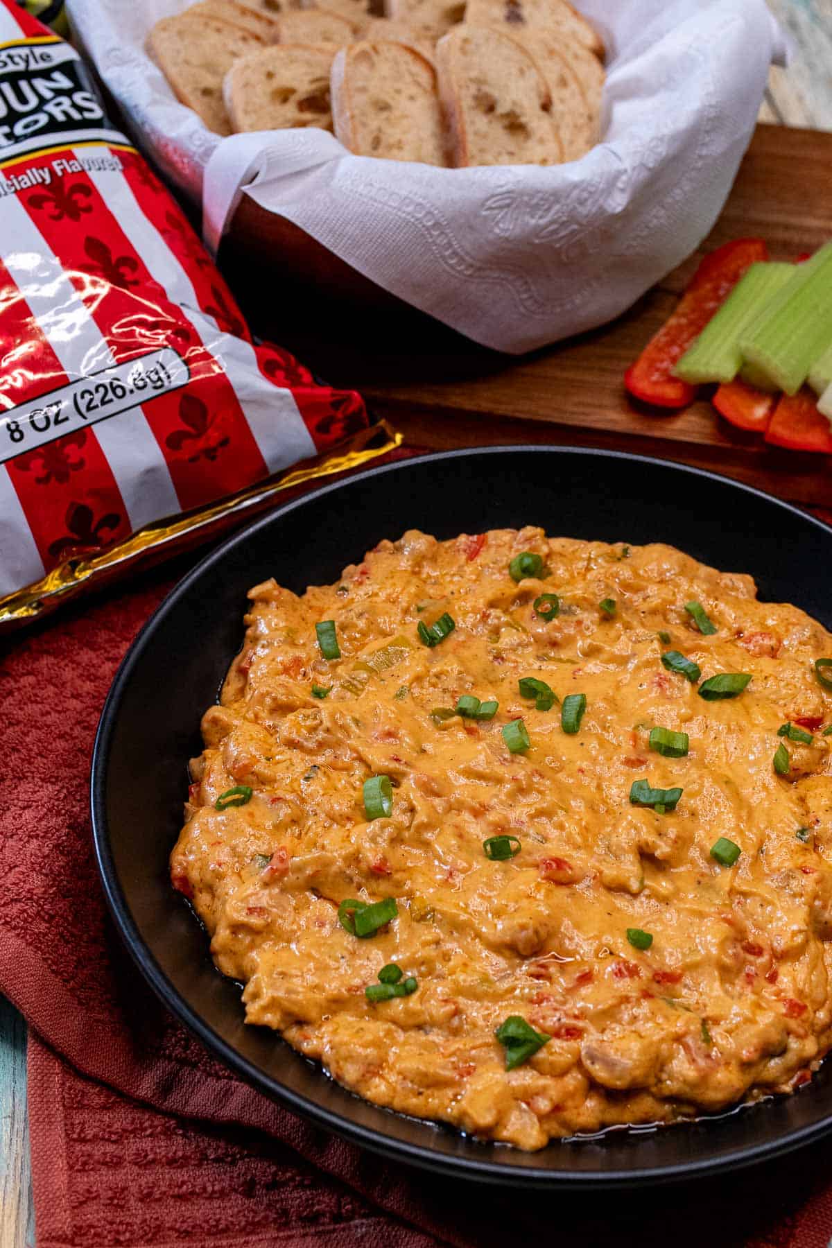 Hot crawfish dip served with chips, toast, and raw vegetables.