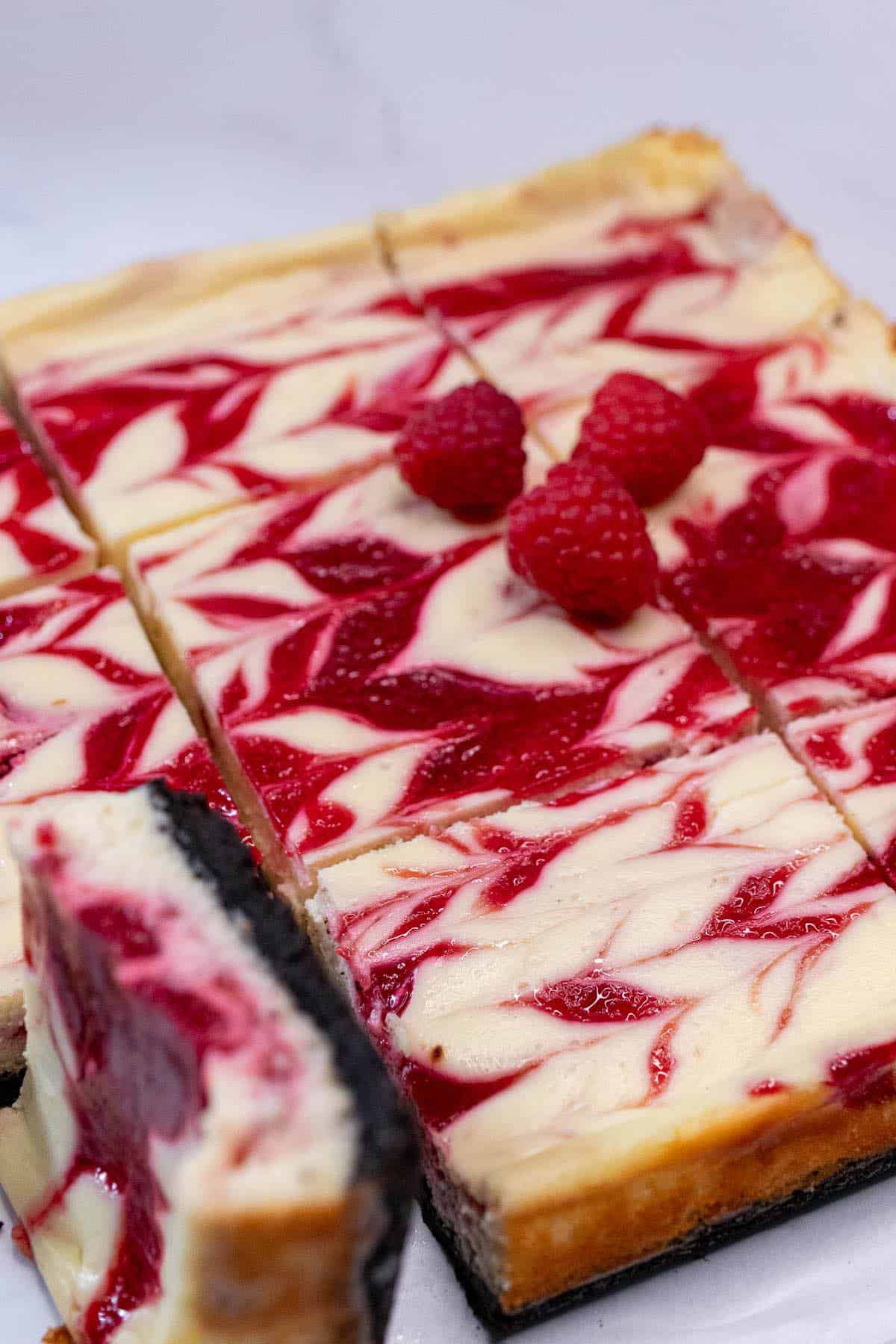 Chilled and sliced white chocolate raspberry cheesecake bars.