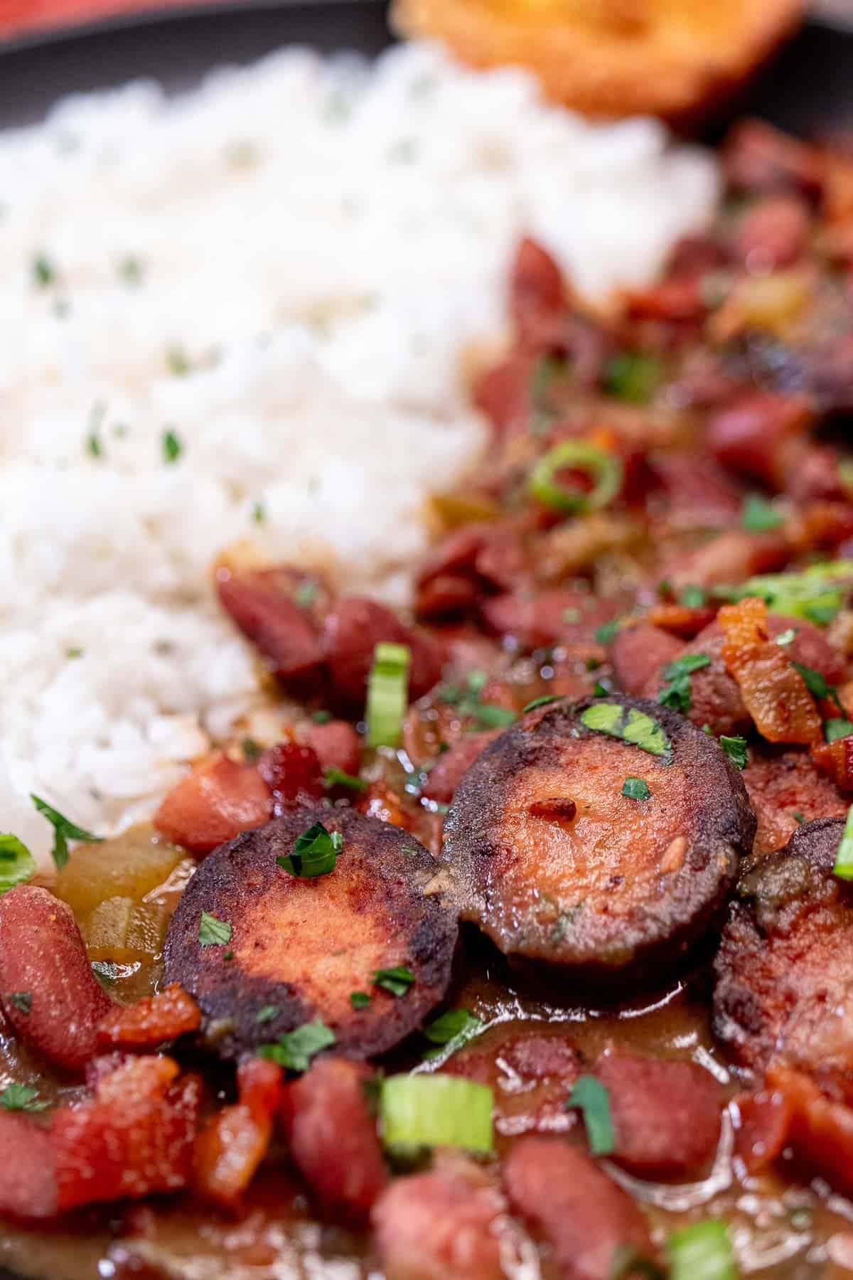 Louisiana red beans and rice served in a plate with white rice and corn bread.