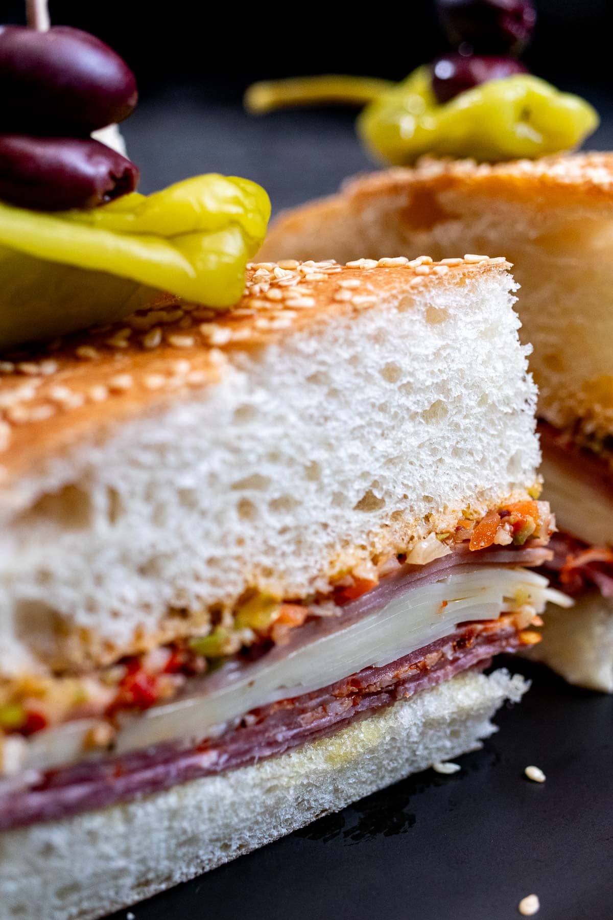 A close view of a sliced quarter from a New Orleans muffuletta sandwich.