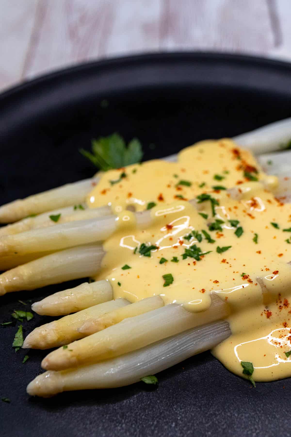 A plate of German white asparagus topped with hollandaise sauce.