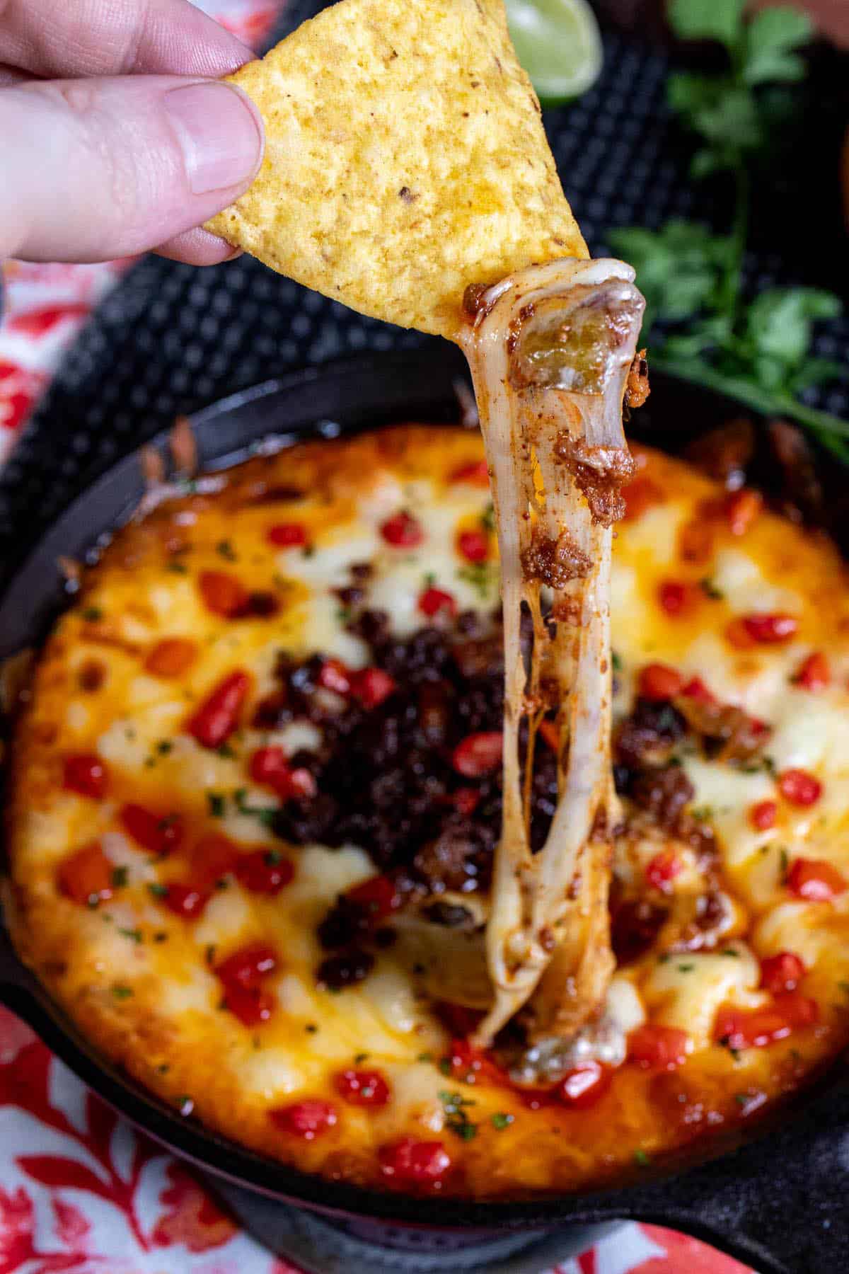 Easting queso fundido with a tortilla chip and getting a big cheese pull out of it.