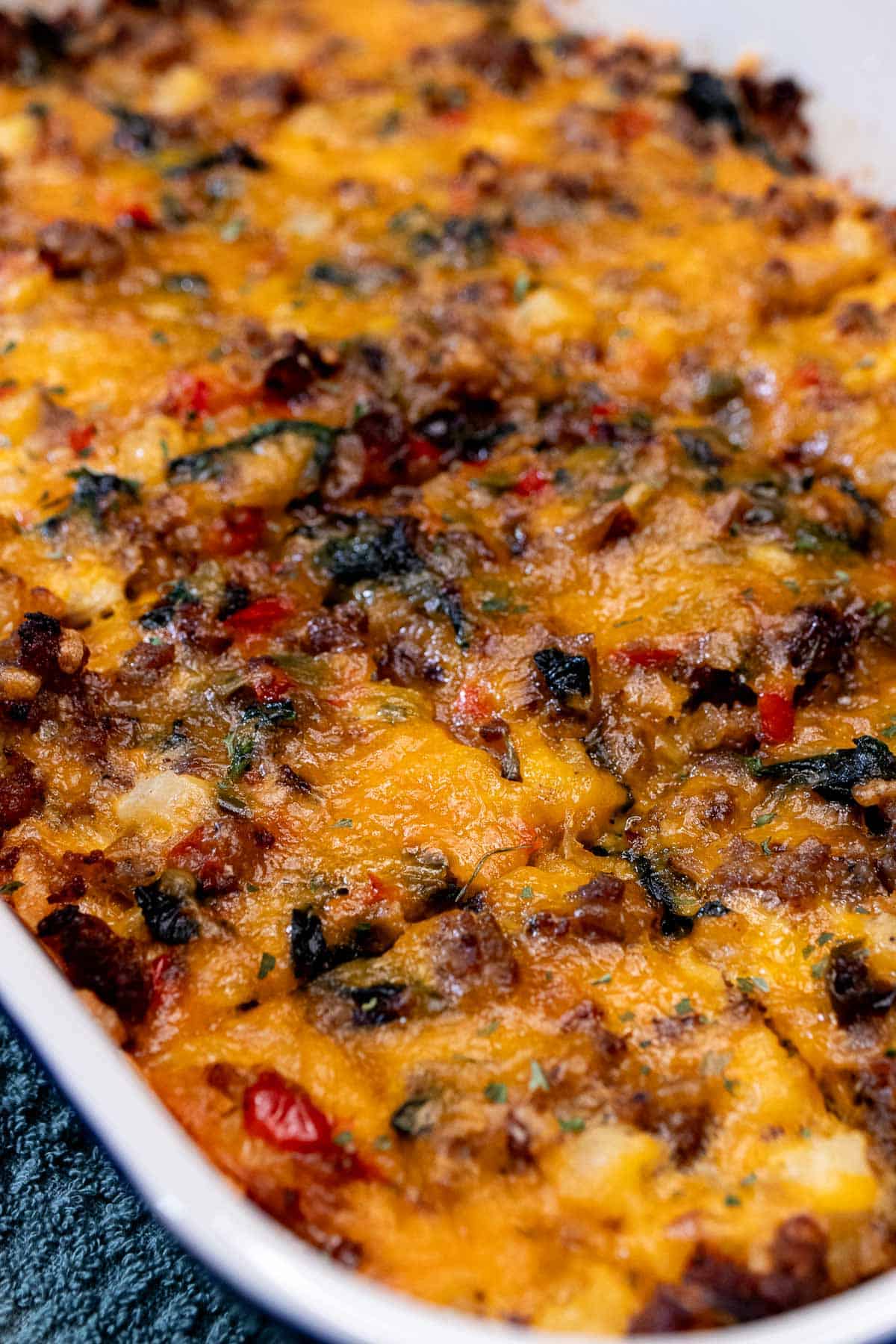 A large baking dish filled with sausage breakfast casserole with slices cut and ready for serving.