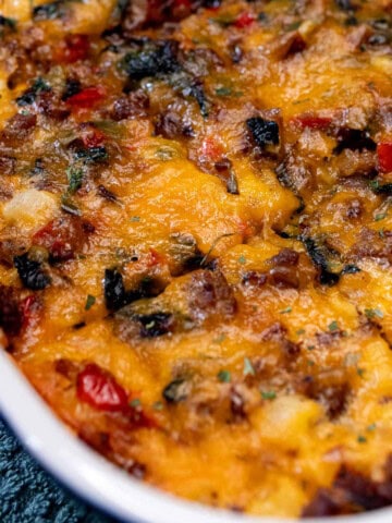 A baking dish full of sausage and egg breakfast casserole with portions cut and ready for serving.
