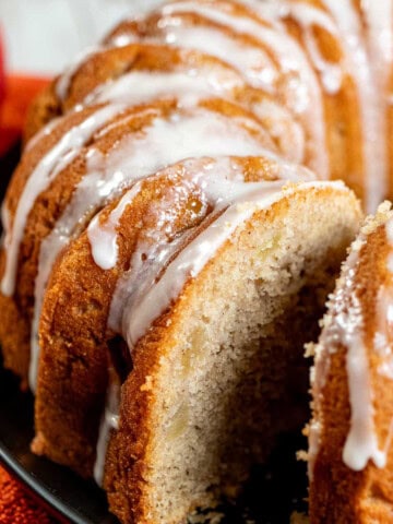 A cider-glazed apple Bundt cake with a slice removed.